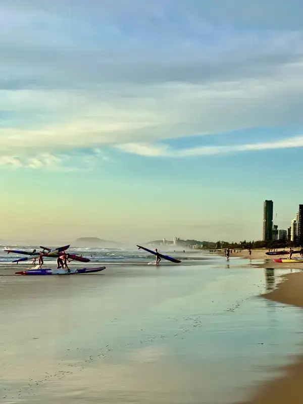 Surfers and kayakers at the beach in Gold Coast at sunrise